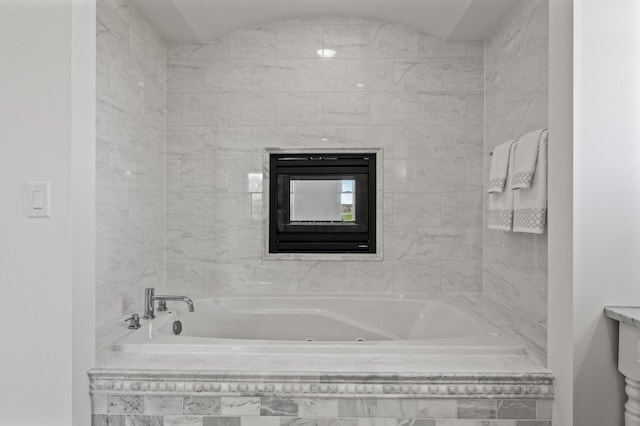 bathroom featuring a tub with jets and vanity