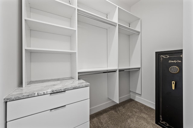 walk in closet featuring dark carpet