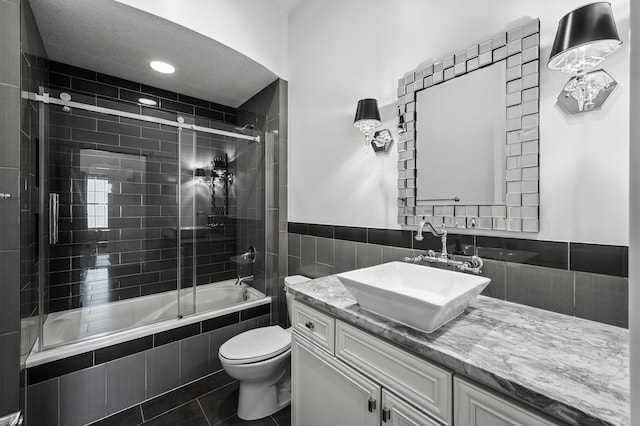 full bathroom featuring vanity, tile patterned flooring, toilet, and tiled shower / bath combo