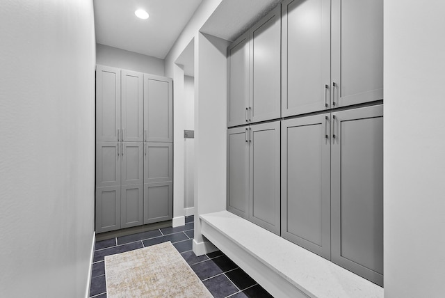 mudroom with dark tile patterned floors, baseboards, and recessed lighting