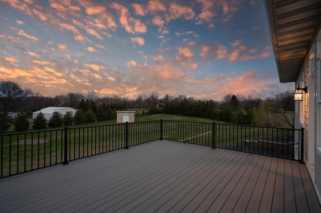 deck featuring a lawn, an outdoor structure, and a shed