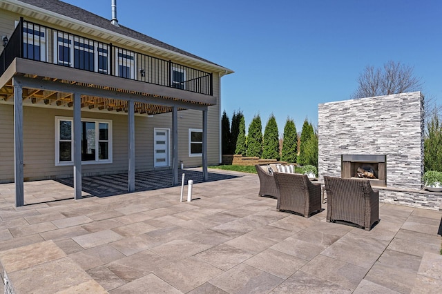 view of patio featuring an outdoor stone fireplace