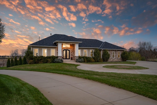 10906 Whitetail Rd, Rogers, MN 55374 - view of front of house with curved driveway, a yard, french doors, and stone siding