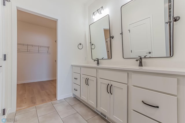 4288 Pine Pkwy S, Fargo, ND 58104 - full bathroom with a sink, a walk in closet, double vanity, tile patterned floors, and baseboards