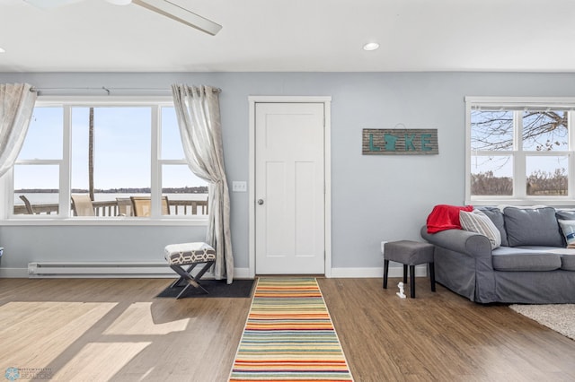 living room with a ceiling fan, wood finished floors, baseboards, recessed lighting, and a baseboard radiator