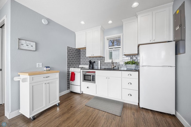 kitchen with white appliances, baseboards, white cabinetry, tasteful backsplash, and dark wood finished floors