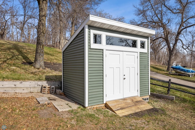 view of shed featuring fence and entry steps