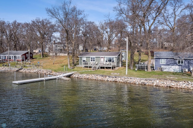 view of dock with a deck with water view and a lawn