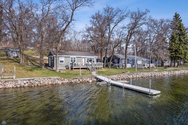 dock area with a yard and a deck with water view
