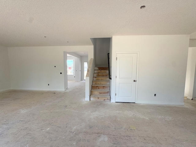 9706 Jasmine Ave NE, Hanover, MN 55341 - spare room featuring a textured ceiling, stairs, and baseboards