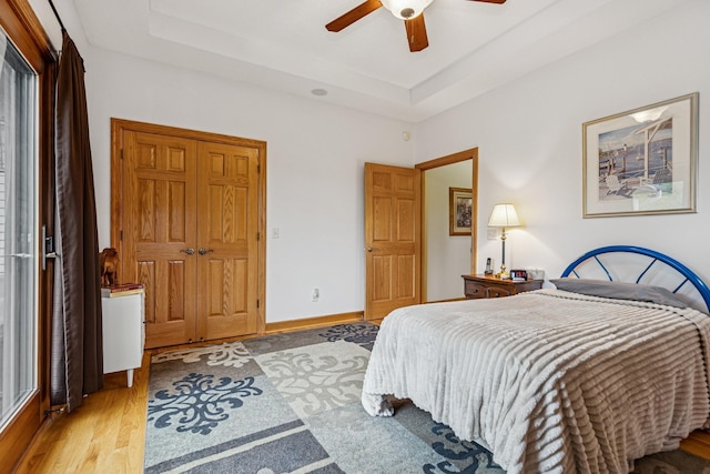 3041 209th Ln NW, Oak Grove, MN 55011 - bedroom featuring wood finished floors, a raised ceiling, ceiling fan, and baseboards