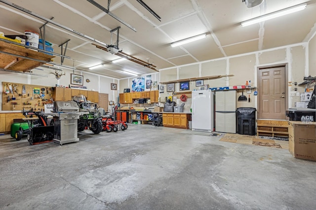 3041 209th Ln NW, Oak Grove, MN 55011 - garage featuring a workshop area, freestanding refrigerator, and a garage door opener