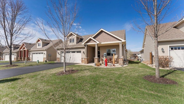 craftsman-style home with a residential view, a front lawn, stone siding, and aphalt driveway