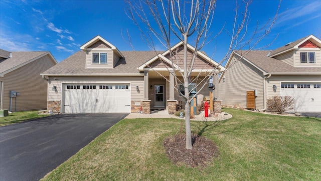 craftsman inspired home with aphalt driveway, a garage, a front lawn, a shingled roof, and stone siding