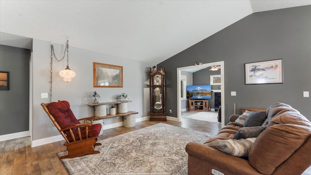 living room with ceiling fan, baseboards, vaulted ceiling, and wood finished floors