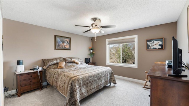 bedroom with a ceiling fan, baseboards, light carpet, and a textured ceiling