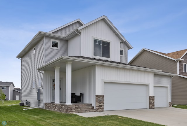 5521 8th St W, West Fargo, ND 58078 - view of front of home featuring a front yard, concrete driveway, an attached garage, and covered porch