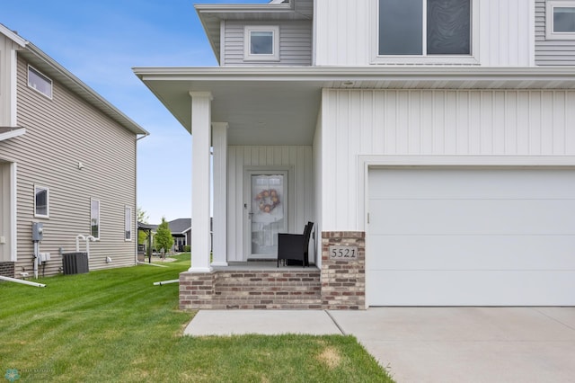 5521 8th St W, West Fargo, ND 58078 - entrance to property featuring a lawn, concrete driveway, an attached garage, and board and batten siding