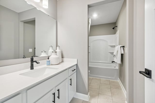 bathroom with vanity, toilet, tile patterned floors, baseboards, and shower / bathing tub combination
