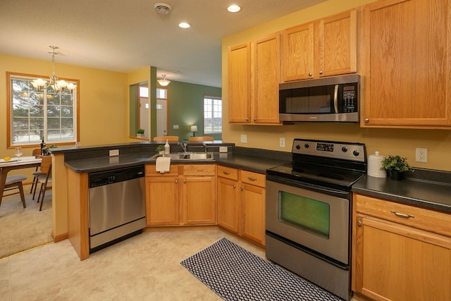 kitchen with dark countertops, a chandelier, stainless steel appliances, recessed lighting, and a peninsula