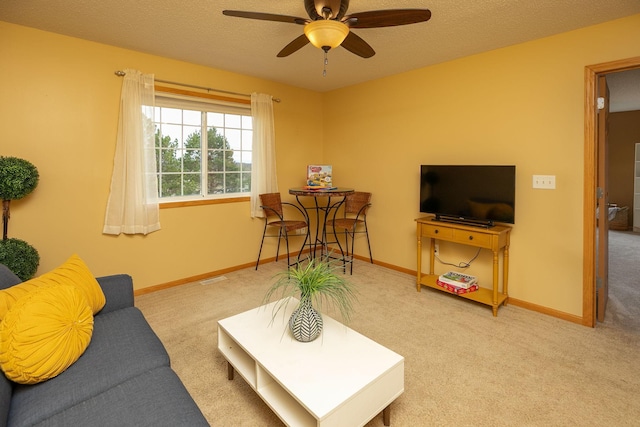 carpeted living room featuring a textured ceiling, ceiling fan, and baseboards