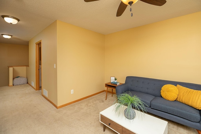living area with a ceiling fan, visible vents, light carpet, and baseboards