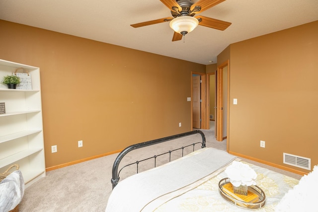 bedroom featuring baseboards, visible vents, a ceiling fan, and light colored carpet