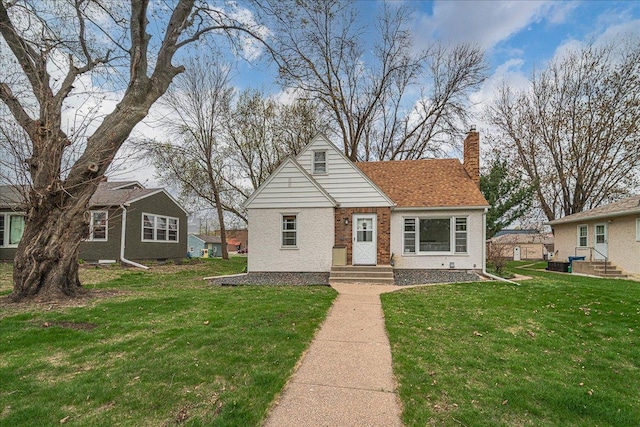 bungalow-style house with brick siding, a chimney, a front yard, and entry steps