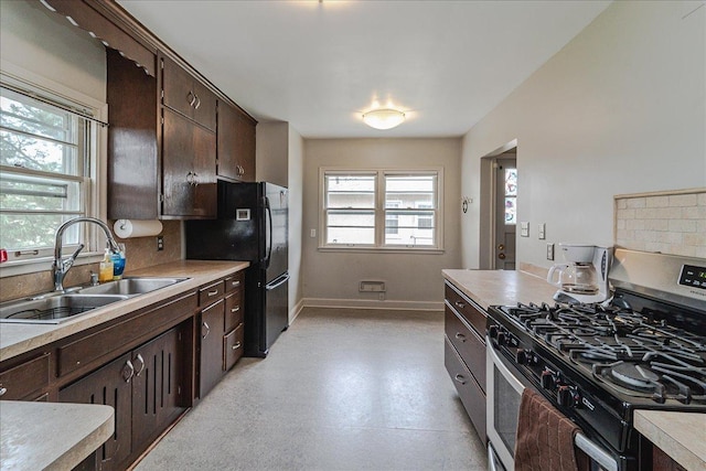 kitchen with stainless steel range with gas cooktop, dark brown cabinetry, plenty of natural light, and a sink
