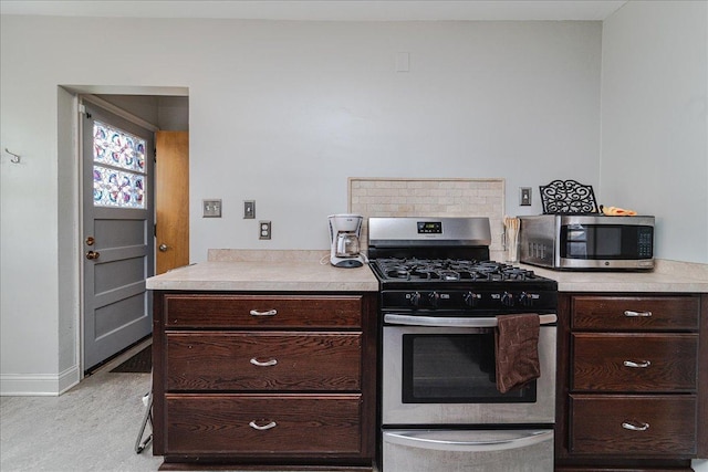 kitchen with baseboards, light countertops, appliances with stainless steel finishes, and dark brown cabinetry