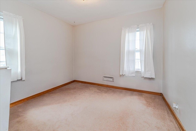 spare room featuring baseboards and carpet