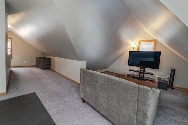 carpeted living area featuring baseboards, vaulted ceiling, a wealth of natural light, and visible vents