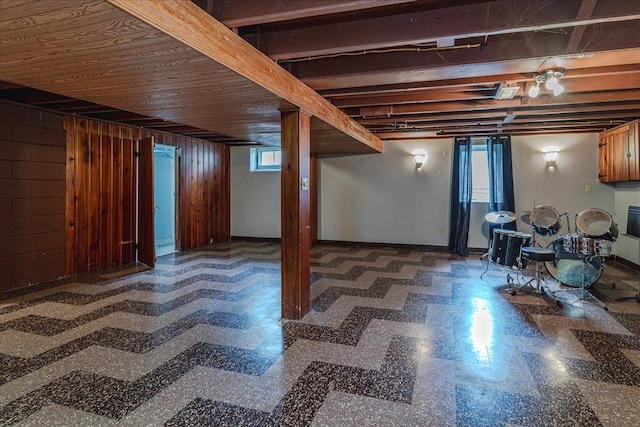 below grade area with a healthy amount of sunlight, tile patterned floors, and wooden walls
