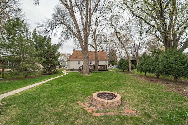 view of yard with a wooden deck and an outdoor fire pit