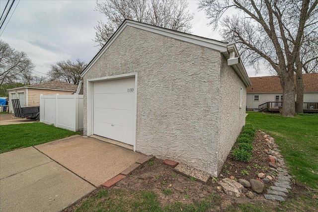detached garage with fence and driveway
