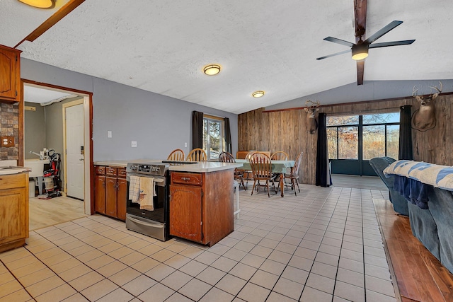 kitchen featuring electric range, a peninsula, lofted ceiling, and light countertops