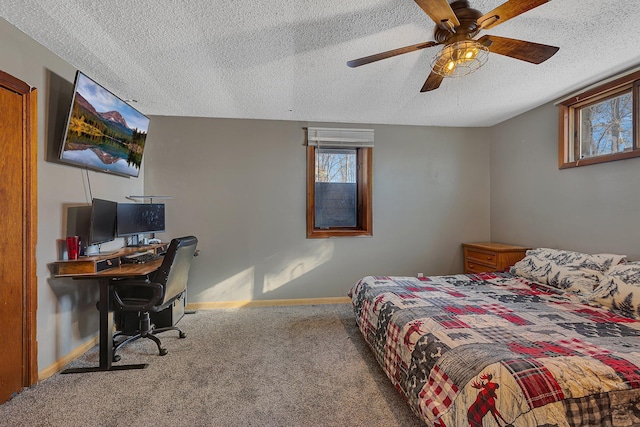 carpeted bedroom featuring a textured ceiling, a ceiling fan, baseboards, and multiple windows