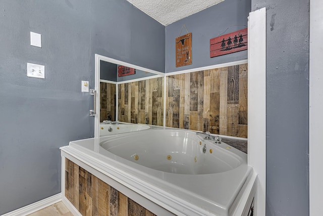bathroom featuring a jetted tub and a textured ceiling