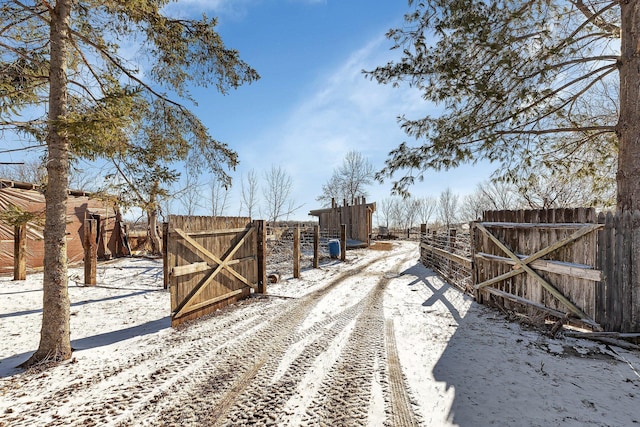 snowy yard with fence and a gate