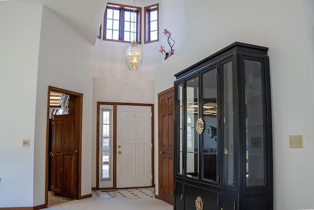entryway featuring a high ceiling, baseboards, and a notable chandelier