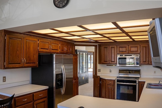 kitchen with light countertops, appliances with stainless steel finishes, and a sink