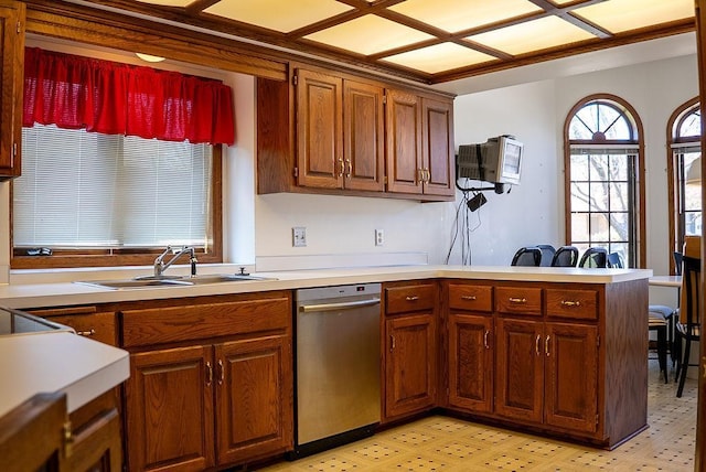 kitchen featuring a sink, dishwasher, light floors, light countertops, and a peninsula