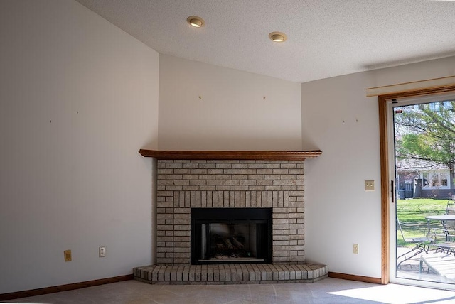 interior details with a textured ceiling, a brick fireplace, and baseboards