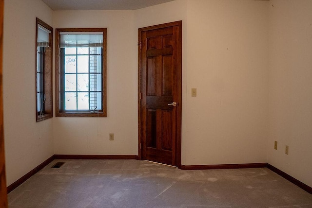 empty room featuring baseboards, carpet flooring, and visible vents