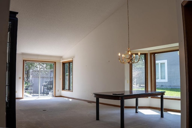 unfurnished dining area featuring carpet flooring, a textured ceiling, baseboards, a chandelier, and high vaulted ceiling