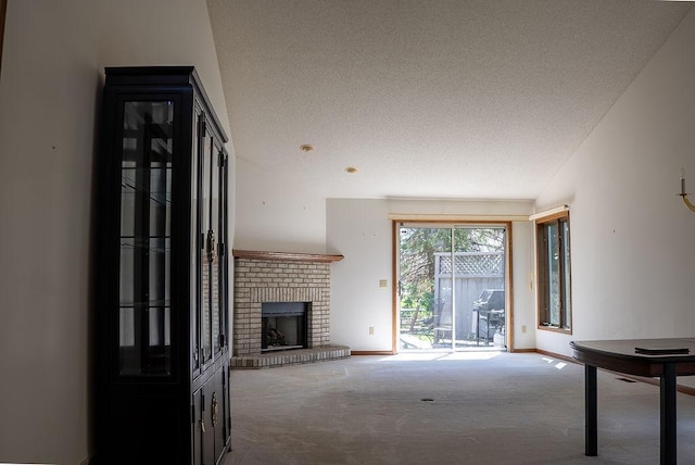 unfurnished living room with a textured ceiling, carpet, a brick fireplace, and baseboards