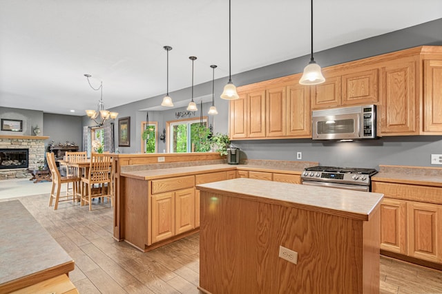 5450 Raven Point Rd, Prior Lake, MN 55372 - kitchen with stainless steel appliances, a kitchen island, light wood finished floors, light countertops, and a fireplace