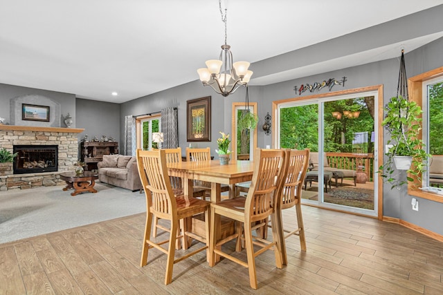 5450 Raven Point Rd, Prior Lake, MN 55372 - dining space featuring light wood finished floors, a chandelier, plenty of natural light, a stone fireplace, and recessed lighting