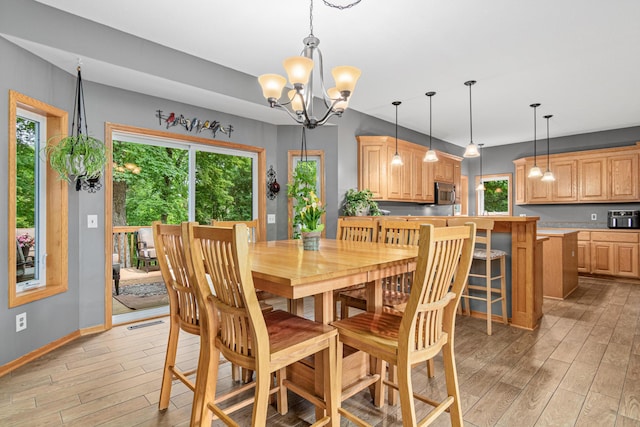 5450 Raven Point Rd, Prior Lake, MN 55372 - dining space with light wood-style floors, a chandelier, and baseboards
