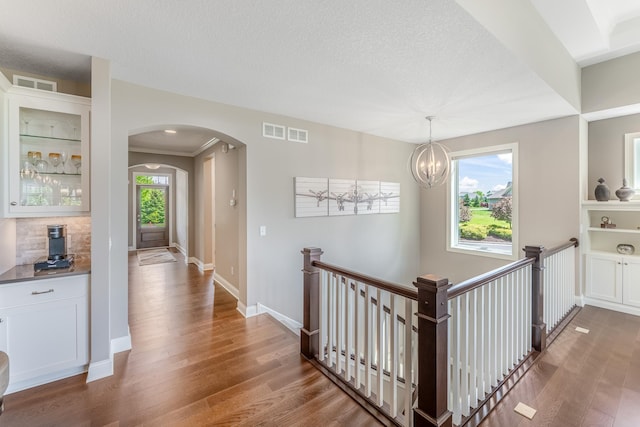 11328 Blazingstar Ln, Lake Elmo, MN 55042 - hallway with wood finished floors, arched walkways, an upstairs landing, baseboards, and a chandelier